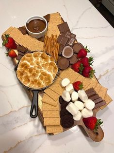 a platter filled with desserts and crackers on top of a marble counter