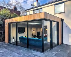 an outdoor living area with sliding glass doors and a blue couch in the middle of it