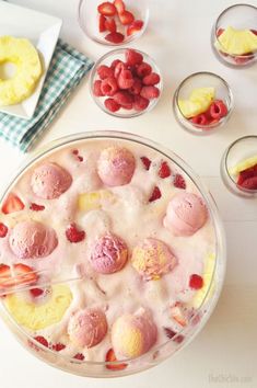 a dessert with strawberries and ice cream in it sitting on a table next to other desserts