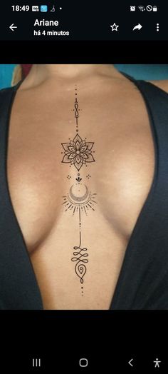 the back of a woman's breast with an intricate tattoo design on her chest