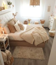 a bedroom with white walls, wooden floors and lots of pillows on top of the bed