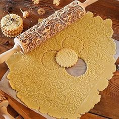 a wooden table topped with lots of different types of cookies and doughnuts next to a rolling pin