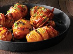 a pan filled with baked potatoes on top of a wooden table