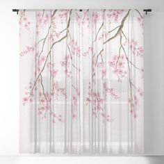 a window curtain with pink flowers and branches on the outside, in front of a white wall