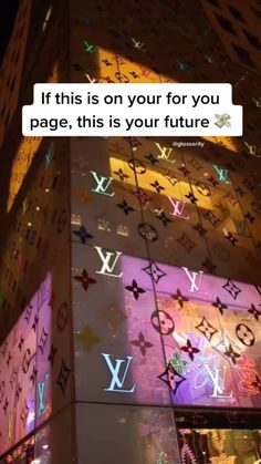 an illuminated building with the words louis vuitton on it