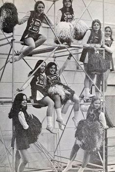 an old black and white photo of cheerleaders on scaffolding