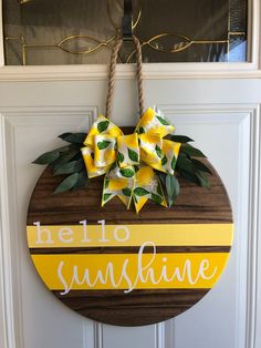 a wooden sign that says hello sunshine hanging on a door with some flowers in it