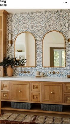 a bathroom with wooden cabinets and two mirrors