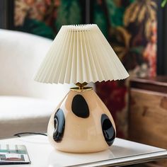 a lamp that is sitting on top of a table in front of a white couch