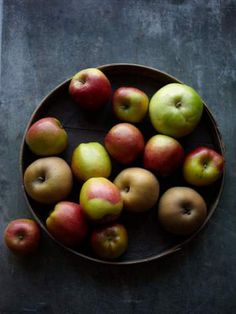 a bowl filled with lots of red and green apples