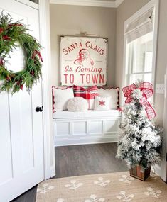 a christmas tree sitting on top of a wooden floor next to a white door and window