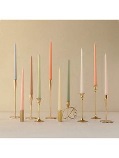 six candles are lined up in different colors and sizes, with one candle standing out from the others