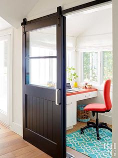 an open door leading to a desk with a computer on it and a red chair