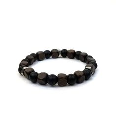 Natural dark brown square wood beads & circular lava stone beads on elasticized bracelet. Bracelet measures approximately 7.5 inches. Materials: 8mm square wood beads, 8mm lava stone beads All items are specially artisan crafted and will be packaged in a black protective jewelry pouch and signature gift box. Care Instructions: Please note that this bracelet is not waterproof. Avoid contact with water or moisture to preserve the life of the bracelet. Adjustable Black Wooden Jewelry, Protective Jewelry, Gifts For Him Christmas, Husband Gifts, Wood Bead Bracelet, Steel Gifts, Gifts For Boyfriend, Father's Day Gifts, Wood Jewelry