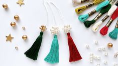 various tassels and beads on a white surface with christmas decorations in the background