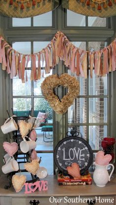 a table that has some decorations on top of it, and a heart hanging from the ceiling