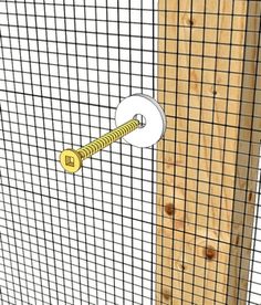 a close up of a fence with a screw in the middle and a piece of wood sticking out of it