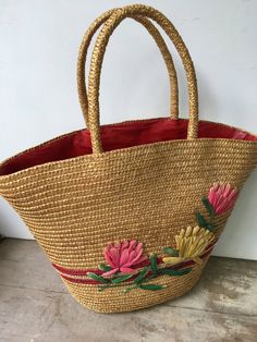 "Vintage straw floral beach bag with stitched raffia lotus blossoms. The bag is lined in a red plastic material. This tote could be used as a small beach bag or a larger summer time purse. Very nice vintage shape, however one of the raffia leaves is not complete. There is also a bit of adhesive residue where there once was either a price tag or manufacturer's tag. Please see all photos. Measurements-at the widest-18\" wide by 12\" tall(not including the handles). The top when opened wide is 9\"x Straw Beach Tote, Pool Bag, Straw Beach Bag, Pool Bags, Christmas Bird, Lotus Blossom, Cat Tail, Red Birds, Wooden Hand