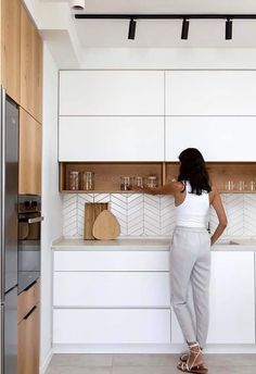 a woman standing in front of a kitchen counter