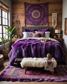 a bed with purple blankets and pillows in a room next to a large painting on the wall