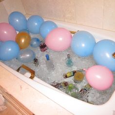 a bathtub filled with lots of balloons and ice