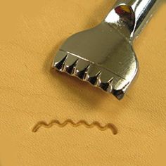 a close up of a small metal object on a yellow surface with holes in it