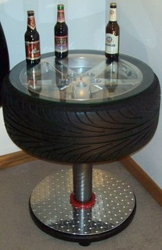 a table made out of an old tire with beer bottles on the top and bottom