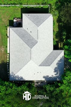 an aerial view of a house in the middle of some trees and grass, looking down on