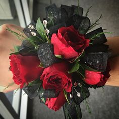 a bridal bouquet with red roses and black ribbon