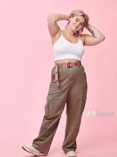 a woman in white shirt and khaki pants posing for the camera with her hand on her head