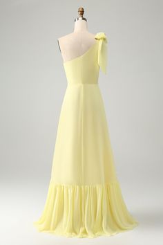 a yellow dress on a mannequin with a large bow at the neckline