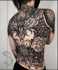 the back of a woman's body covered in tattoos