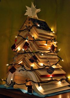 a christmas tree made out of books and lights