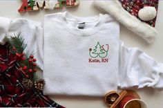 Christmas Sweatshirt-Holiday Sweatshirt-Christmas Sweater-Nurse Sweatshirt-Personalized Gift-Custom Embroidered Sweatshirt-Nurse Gift-RN Sweatshirt-Nursing Student-Nurse Shirt-Nursing Sweatshirt-Nurse Graduation Gift-NICU Nurse-Christmas Gift This custom embroidered sweatshirt is super soft, unisex in size and makes a trendy sweatshirt to wear with during the Holiday Season! Also makes a wonderful nurse holiday gift or a gift for any present or future nurse! * Main photo shows White Sweatshirt w Nursing Sweatshirt, Custom Embroidered Sweatshirt, Christmas Gifts For Nurses, Green Thread, Student Nurse, Nursing Student Gifts, Nurse Graduation, Show White, Nurse Graduation Gift