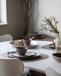 a white table topped with plates and bowls