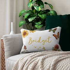 a white couch with a pillow that says bridget on it and sunflowers