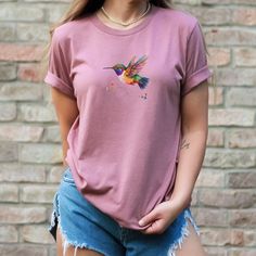 Hummingbird Shirt Watercolor Bird T-Shirt Nature Lover T Shirt Wildflower Shirt Bird Lover Gift for Her Hummingbird Lover Gift This classic unisex jersey short sleeve tee fits like a well-loved favorite. Soft cotton and quality print make users fall in love with it over and over again. These t-shirts have-ribbed knit collars to bolster shaping. The shoulders have taping for better fit over time. Dual side seams hold the garment's shape for longer.  .: 100% Airlume combed and ringspun cotton (fiber content may vary for different colors) .: Light fabric (4.2 oz/yd² (142 g/m .: Retail fit .: Tear away label .: Runs true to size Thanks for visiting my shop! Please feel welcomed to check out my other items in my shop at https://lylasshoppe.etsy.com. Kind Regards, Pam Summer Crew Neck T-shirt With Bird Print, Casual Crew Neck T-shirt With Bird Print, Casual Summer T-shirt With Bird Print, Mama Bird Shirt, German Shepherd Mom Shirt, Wildflower Shirt, Corgi Mom, Bird Shirt, Comfort Colors Tshirt