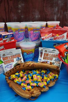 a table topped with lots of different types of candy and snacks in buckets next to each other