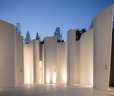 an empty room with white walls and lights on the wall, at dusk or dawn