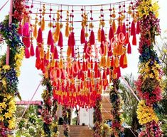 a bunch of tassels hanging from the side of a building next to flowers