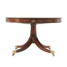 a wooden table with two brass handles on it's legs and an oval top