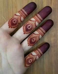 hendi tattoos on the palm of someone's hand with their fingers painted red and white