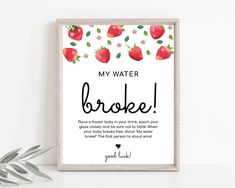 a framed poster with the words, my water broke and strawberries on it next to a potted plant