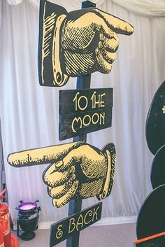 there is a sign that says to the moon and 3 back hand pointing at each other