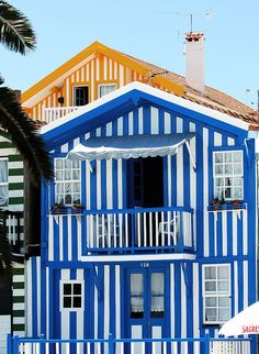 a blue and white striped building next to palm trees