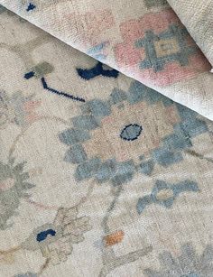 an old rug is laying on top of the floor with it's fabric pulled back