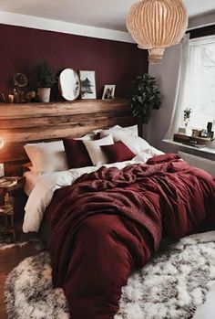 a bedroom with red walls and white fur rugs on the floor, along with a large bed