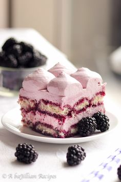 a piece of cake on a plate with blackberries