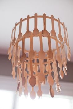 a wooden chandelier with spoons and forks hanging from it