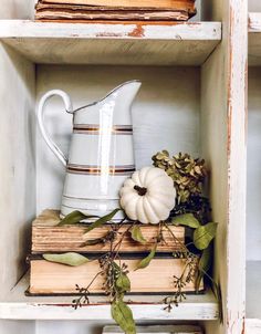 a shelf filled with books and vases on top of each other